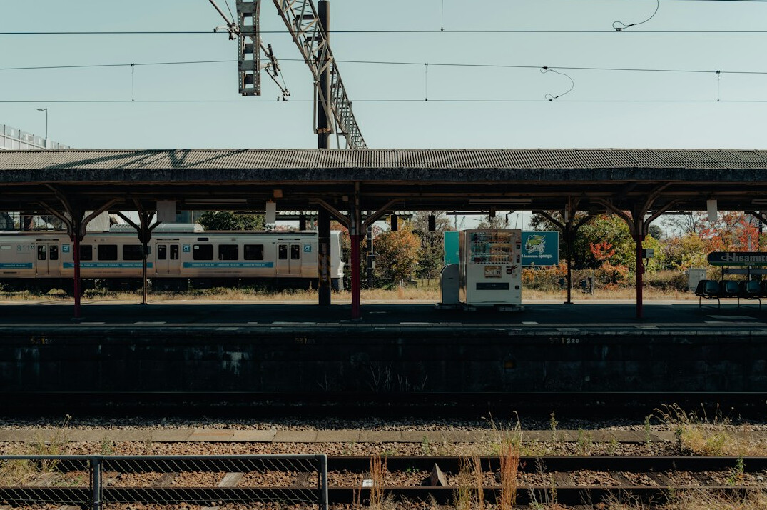 Abandoned railway station platform with rusty rails