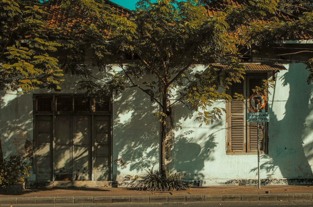 Old colonial house with closed wooden shutters on a quiet street